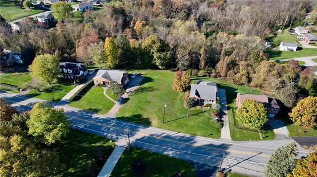 an aerial view of a house with a yard and lake