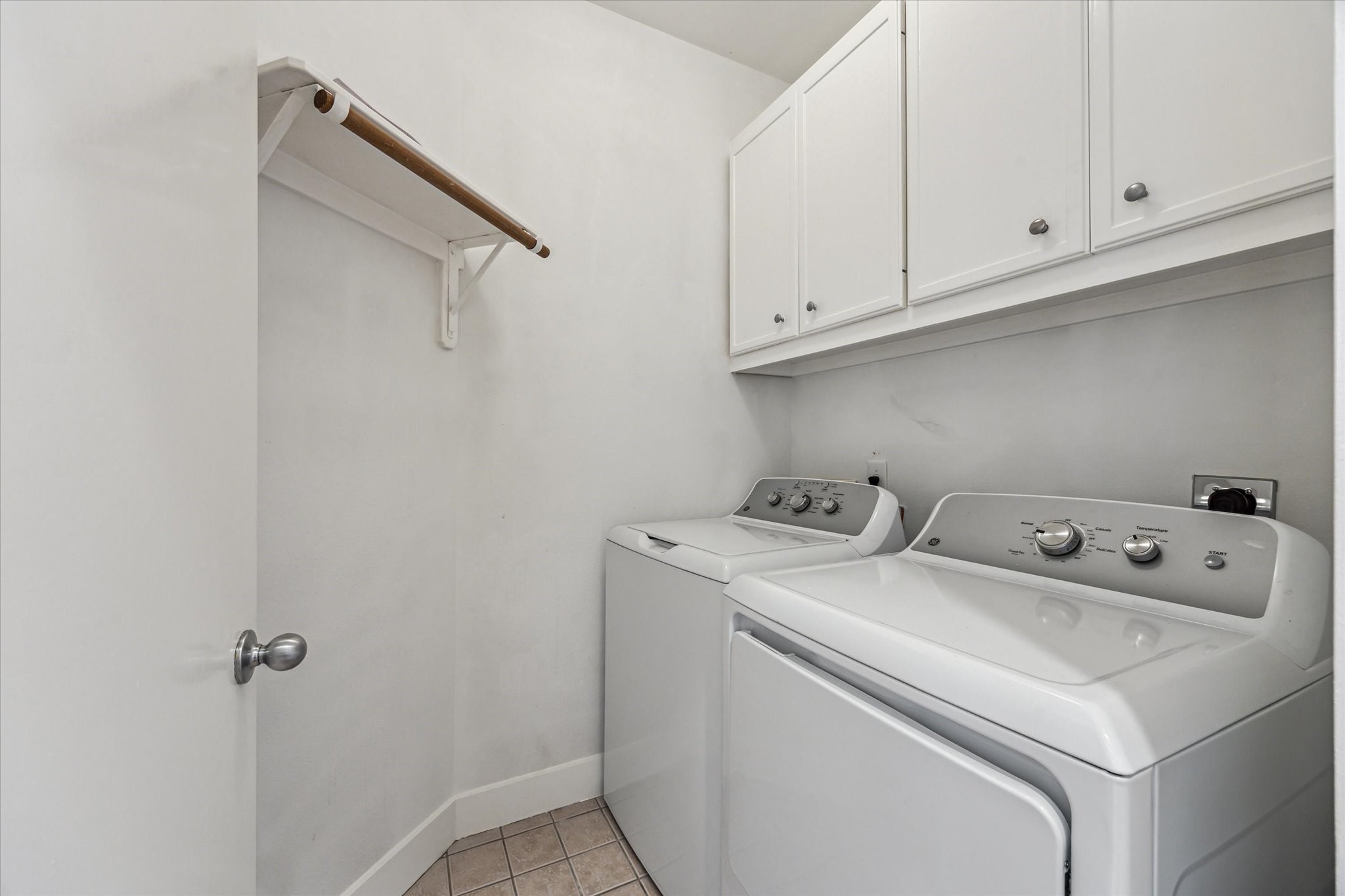 9829 Riddlelink Lane Houston, TX 77025 - Photo 18 of 22 Convenient full-size laundry area with washer, dryer, and overhead storage.