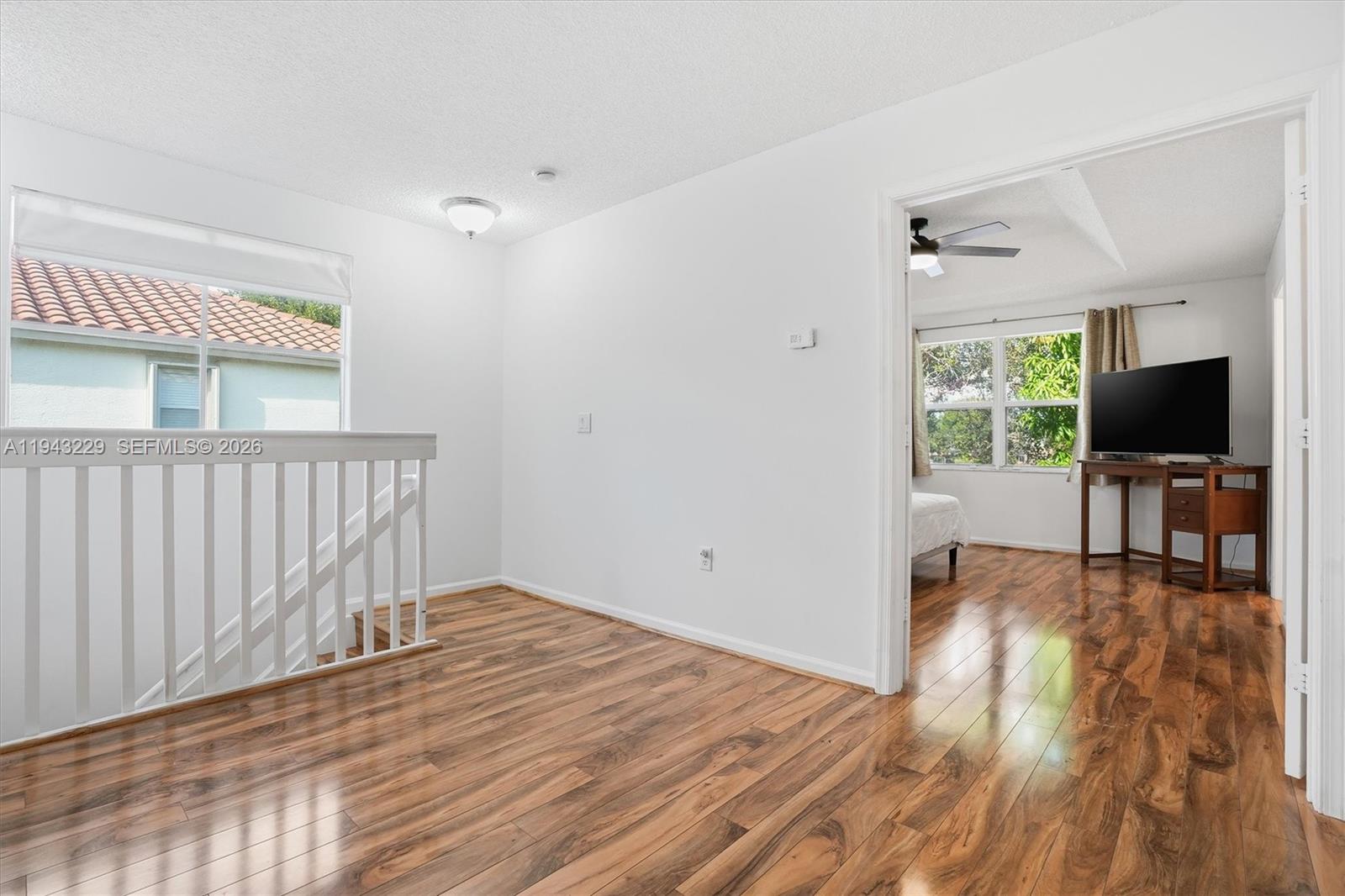 16367 Southwest 48th Street Miramar, FL 33027 - Photo 12 of 41 a view of a livingroom with wooden floor and a flat screen tv