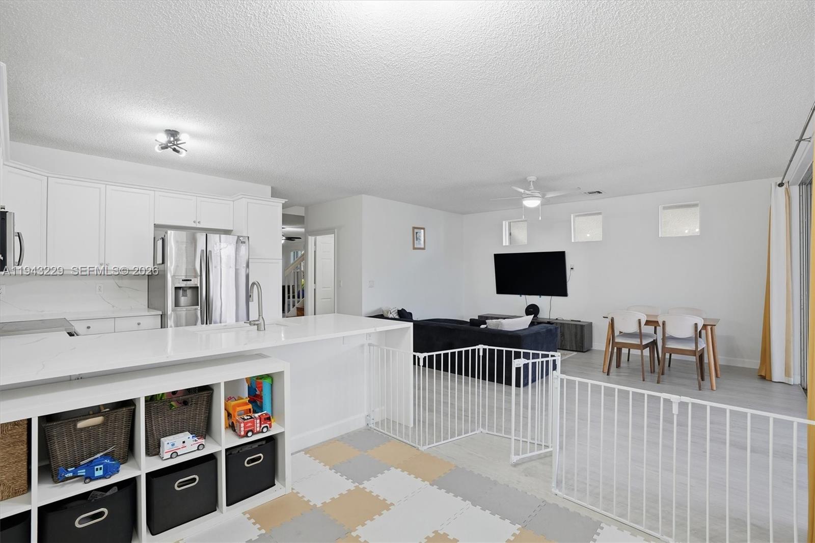 16367 Southwest 48th Street Miramar, FL 33027 - Photo 7 of 41 a living room with furniture a flat screen tv and kitchen view