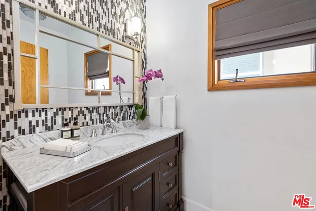 a bathroom with a granite countertop sink and a mirror