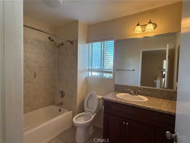 a bathroom with a granite countertop sink toilet a large mirror a bathtub and shower