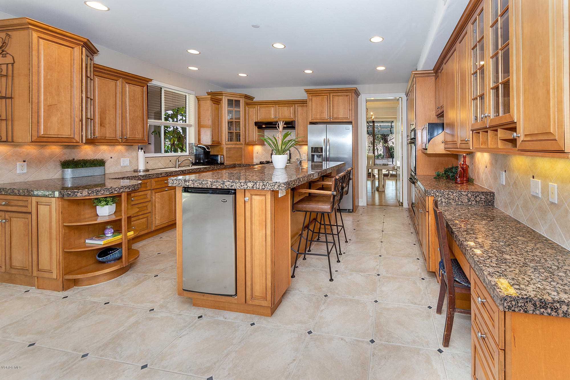 10089 Stockton Road Moorpark, CA 93021 - Photo 4 of 39 a kitchen with stainless steel appliances granite countertop a stove top oven a sink a dining table and chairs with wooden floor