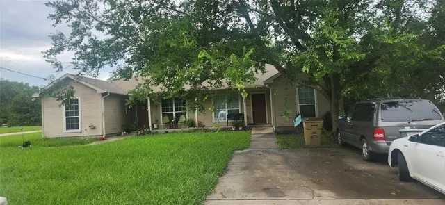 a view of a house with a patio and a yard