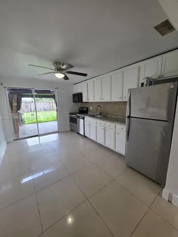 a kitchen with stainless steel appliances granite countertop a refrigerator and a stove