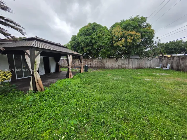 a backyard of a house with childrens swings and slides