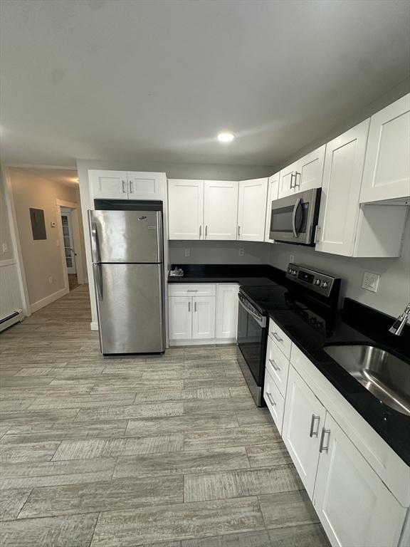 30 Clement Avenue, Unit 2 Peabody, MA 01960 - Photo 5 of 35 a kitchen with granite countertop a refrigerator a sink and white cabinets