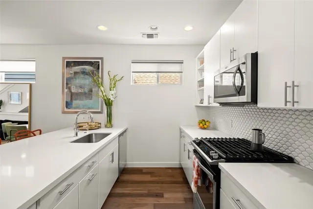 a kitchen with stainless steel appliances granite countertop a stove a sink and a refrigerator