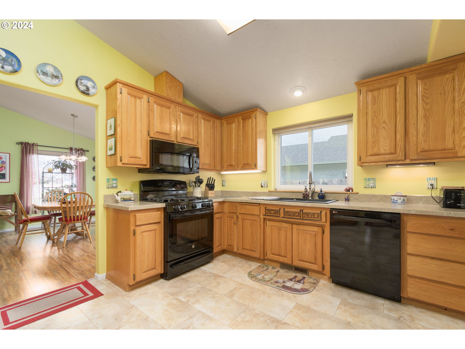 2969 Brett Loop Eugene, OR 97404 - Photo 14 of 33 a kitchen with granite countertop a stove top oven a sink dishwasher and cabinets with wooden floor