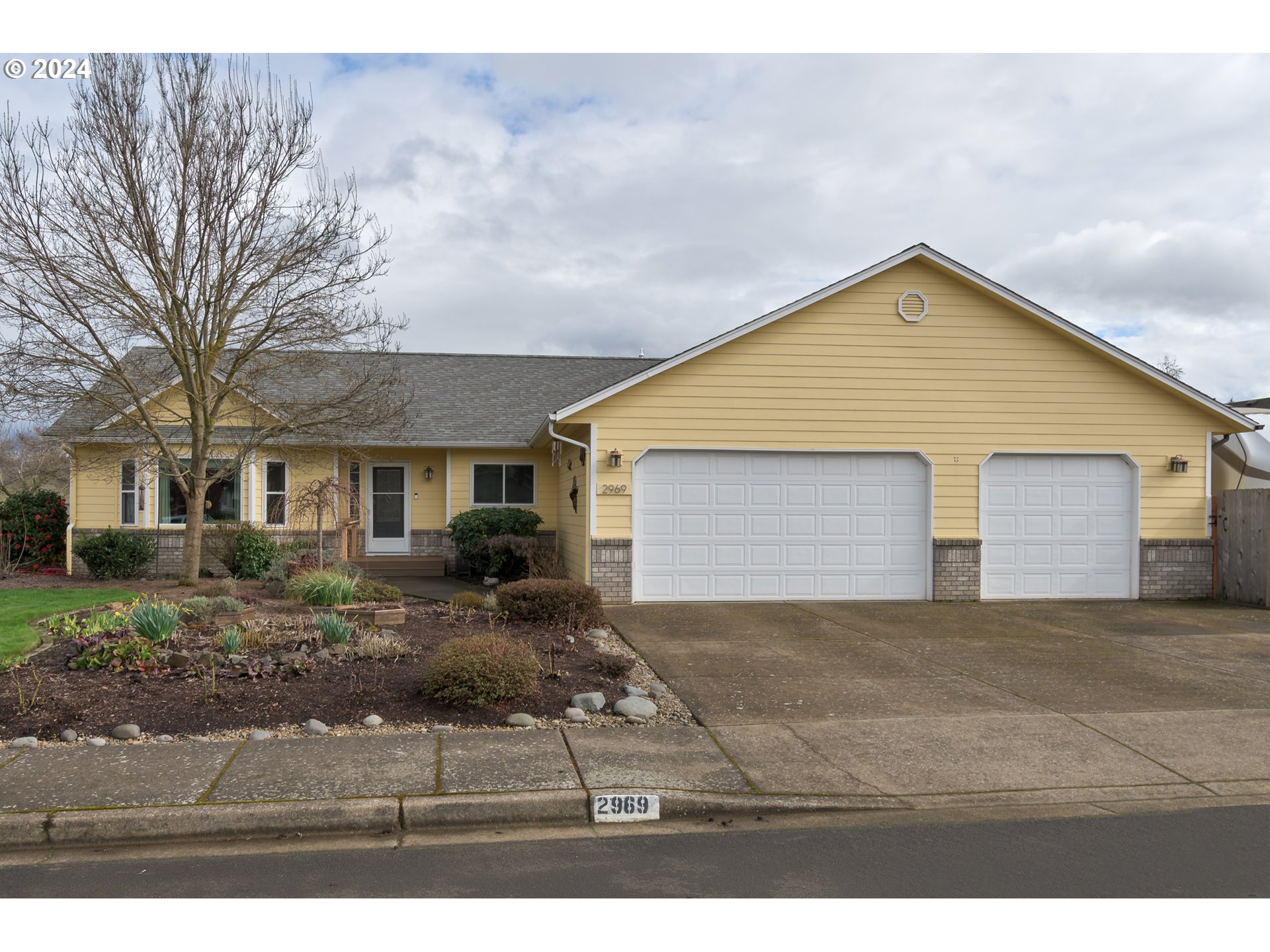 2969 Brett Loop Eugene, OR 97404 - Photo 2 of 33 a view of a yard in front of a house with large windows