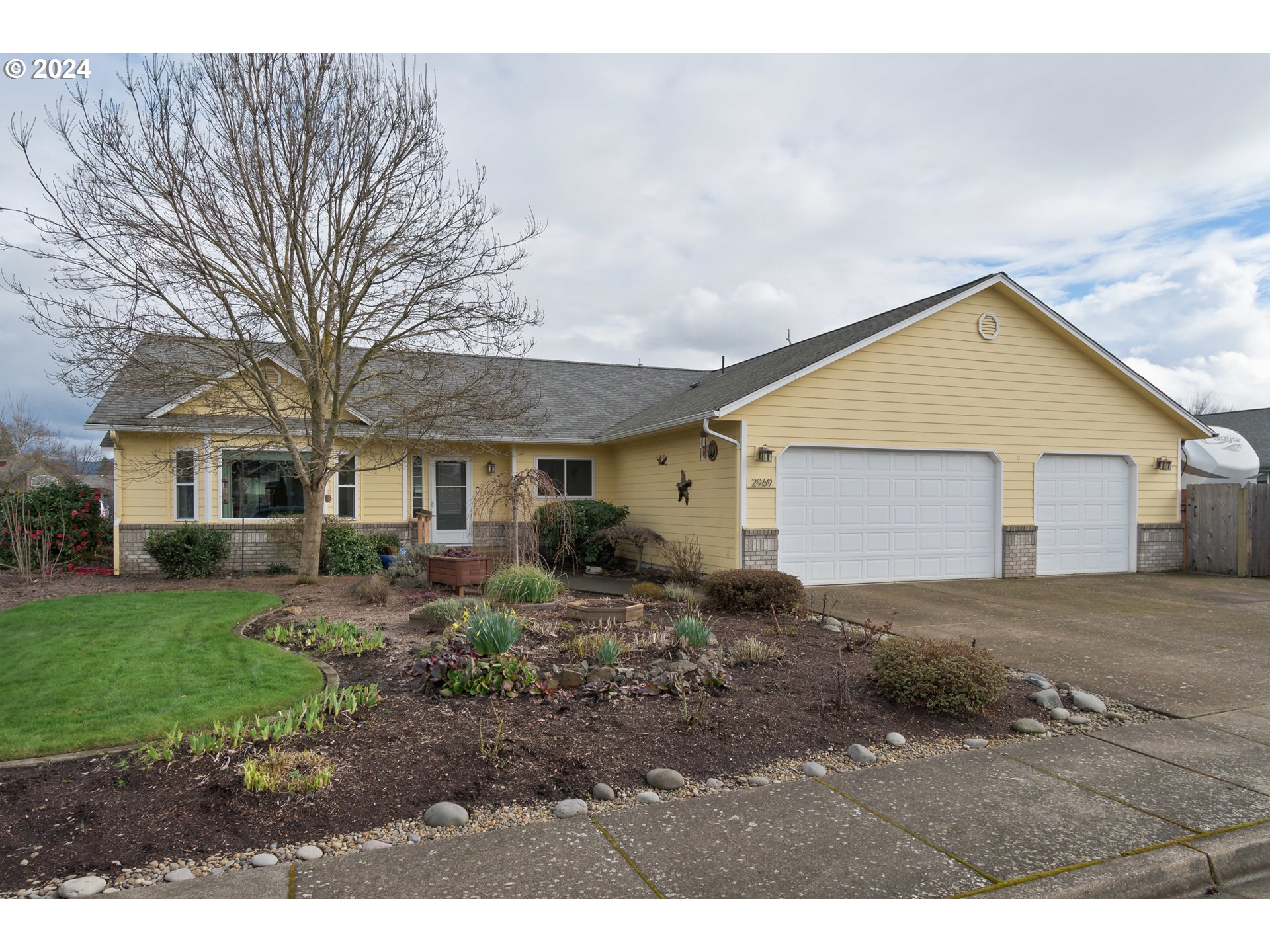 2969 Brett Loop Eugene, OR 97404 - Photo 3 of 33 a view of a yard in front of a house with large windows