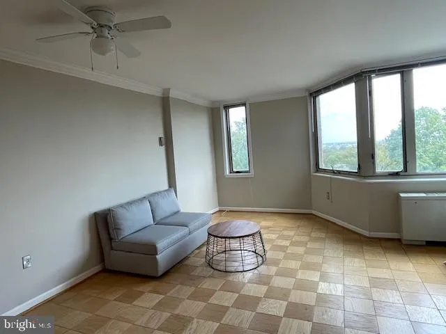 a living room with furniture ceiling fan and a window