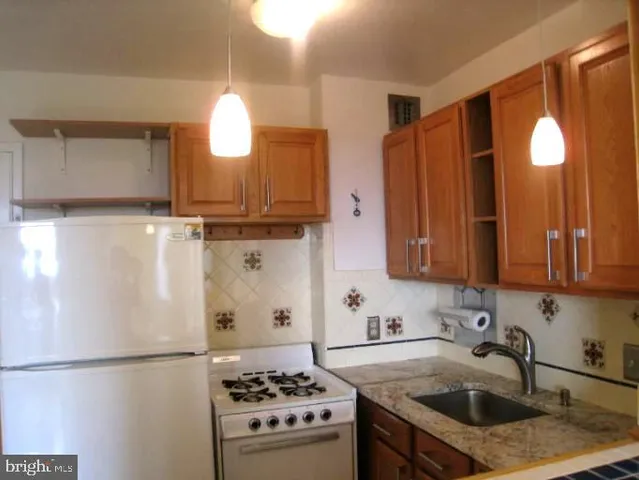 a kitchen with a sink a stove and a refrigerator