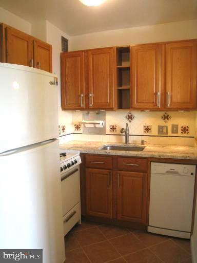 2800 Wisconsin Avenue Northwest, Unit 601 Washington, DC 20007 - Photo 7 of 28 a kitchen with a sink a stove and a refrigerator