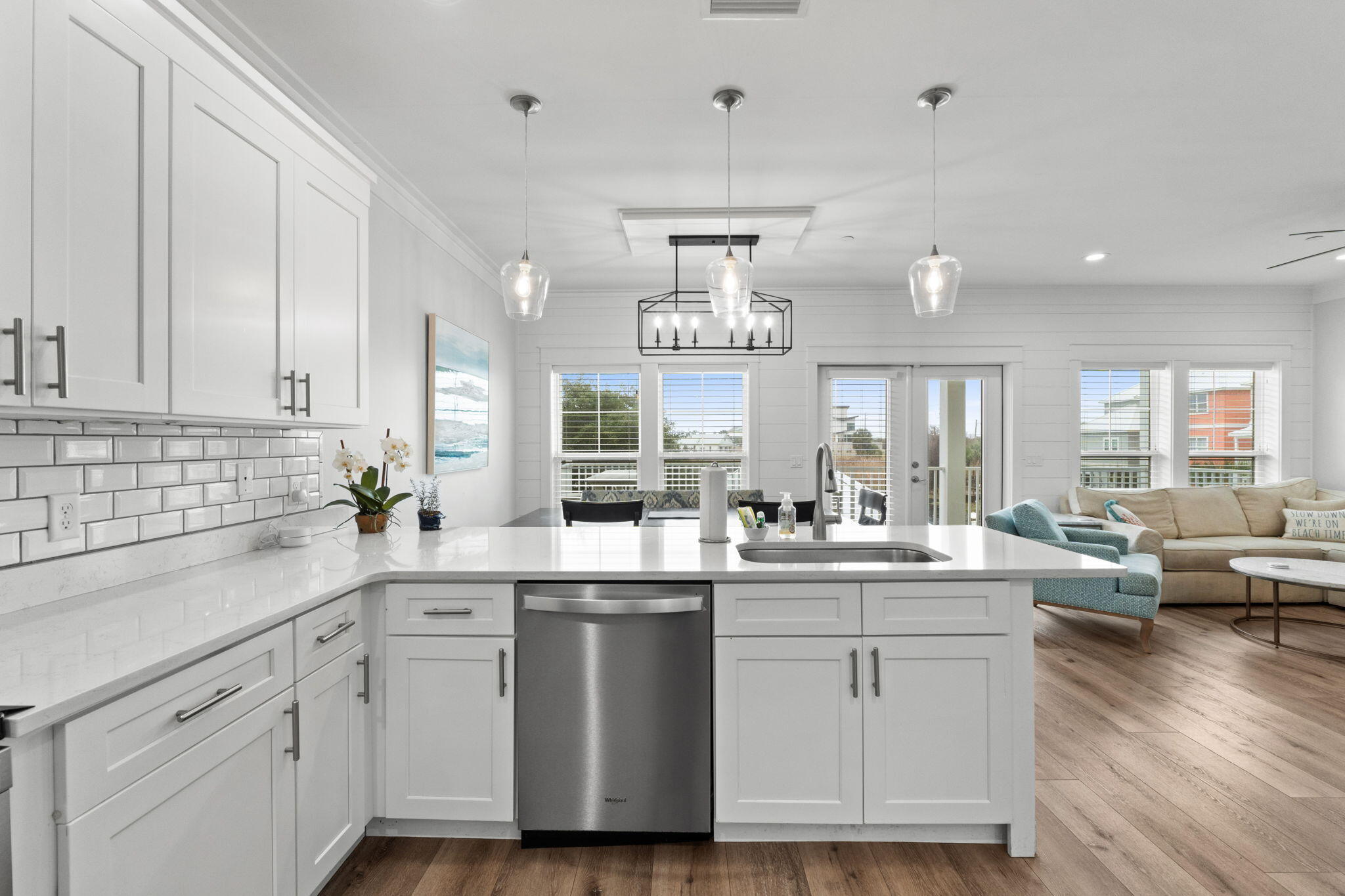 116 Riviera Drive Panama City Beach, FL 32413 - Photo 29 of 66 a kitchen with a sink dishwasher stove and white cabinets with wooden floor