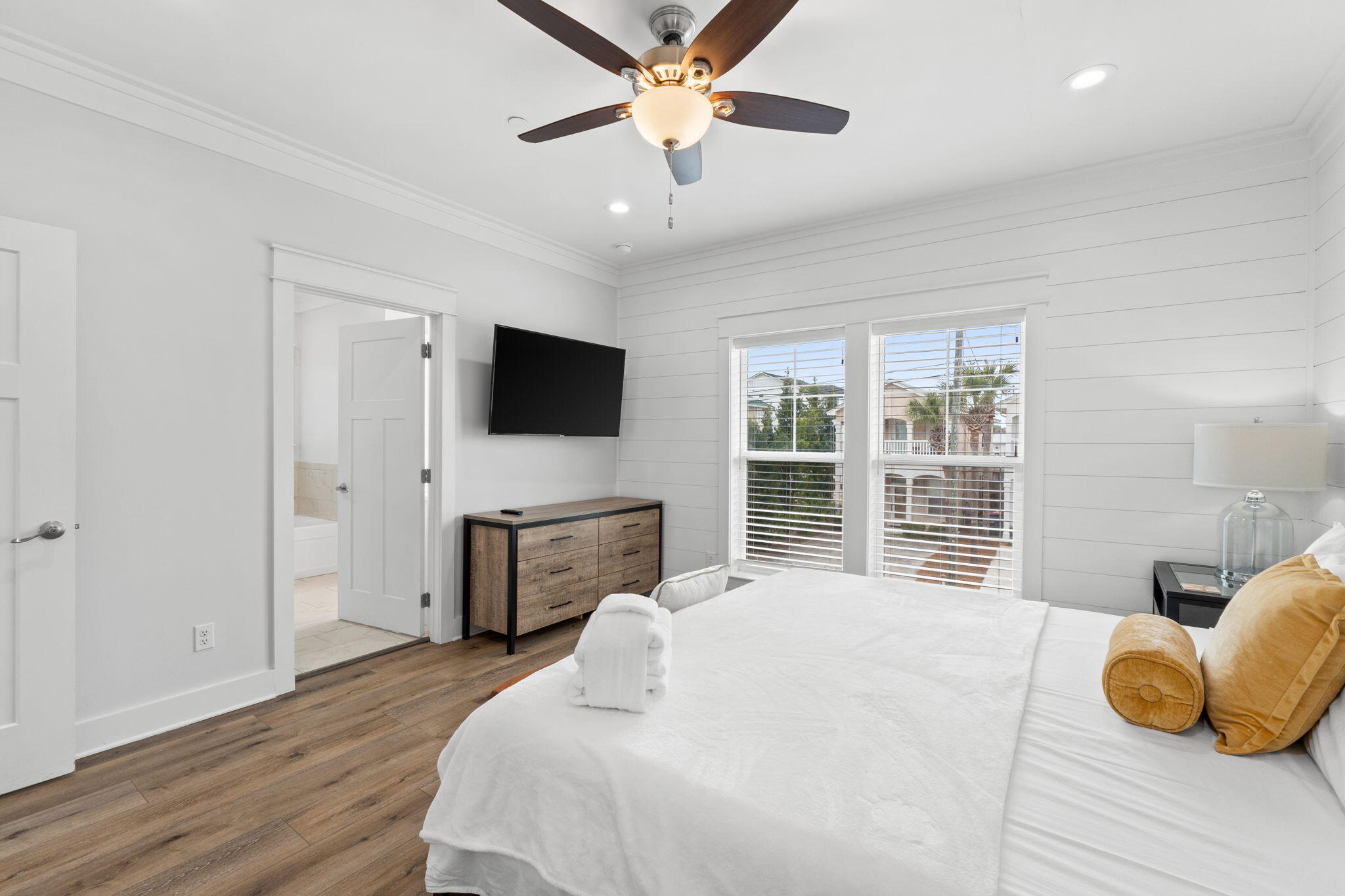 116 Riviera Drive Panama City Beach, FL 32413 - Photo 32 of 66 a bedroom with a bed flat screen tv and a chandelier