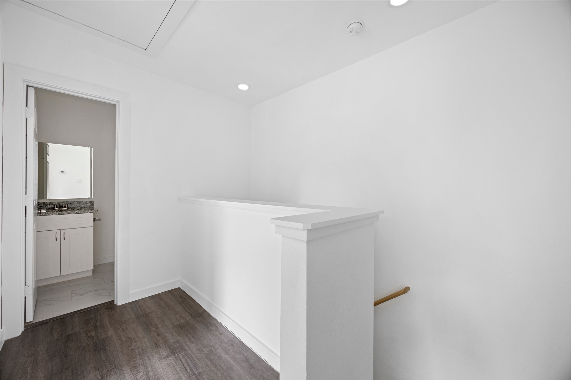 9243 Seeker Street Houston, TX 77028 - Photo 13 of 22 a view of an empty room with wooden floor and a kitchen
