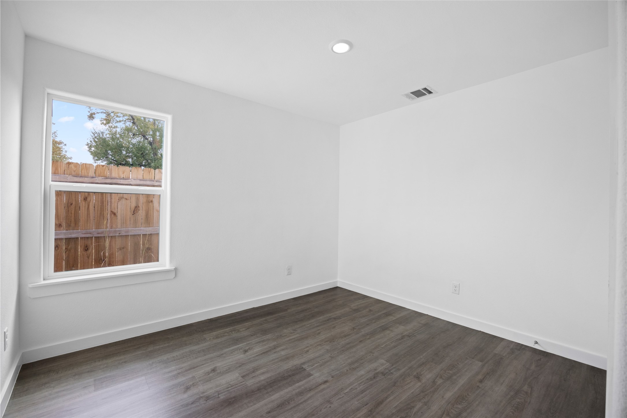 9243 Seeker Street Houston, TX 77028 - Photo 17 of 22 a view of an empty room with wooden floor and a window