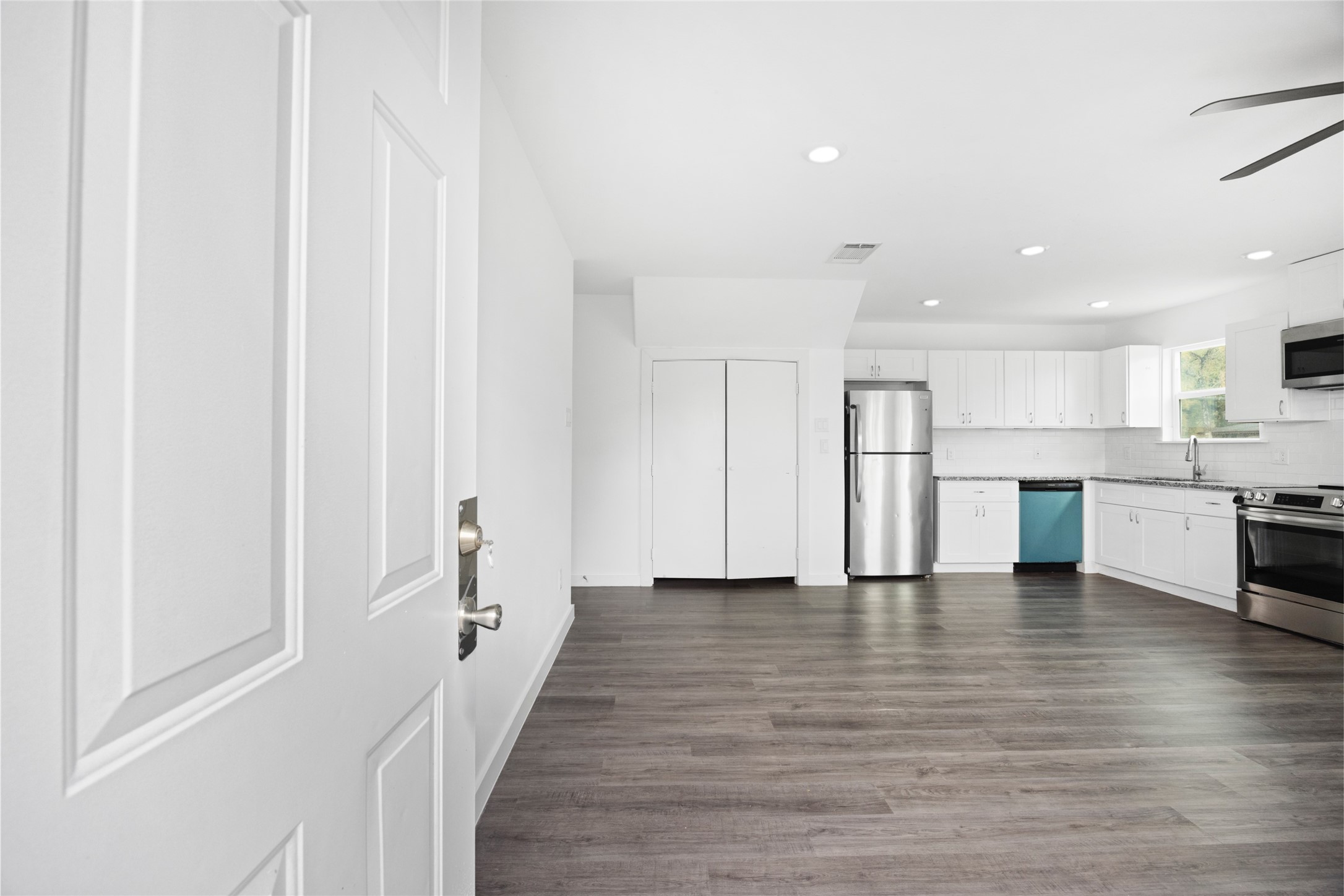 9243 Seeker Street Houston, TX 77028 - Photo 3 of 22 a view of a kitchen with white cabinets and stainless steel appliances