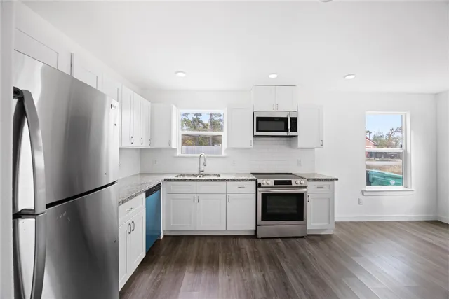 a kitchen with stainless steel appliances a refrigerator sink and microwave