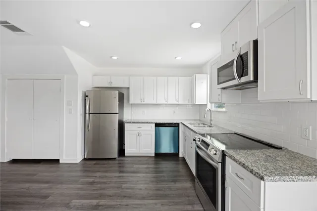 a kitchen with a sink a refrigerator and a oven
