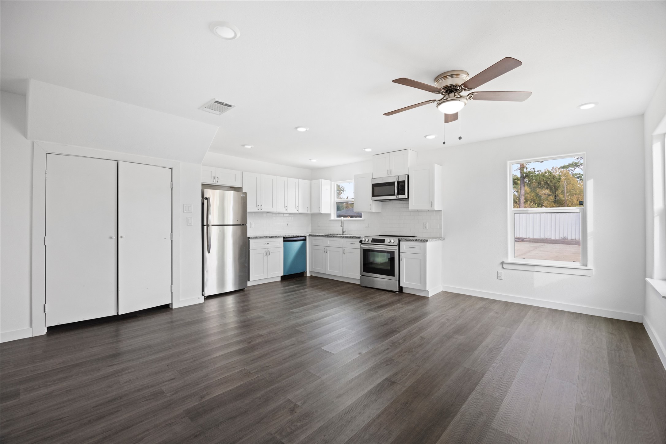 9243 Seeker Street Houston, TX 77028 - Photo 7 of 22 a view of a kitchen with a sink stainless steel appliances wooden floor and a window