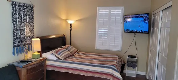 a bedroom with bed and a flat screen tv