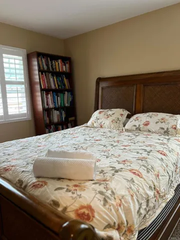a bed sitting in a bedroom next to a window