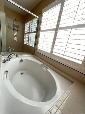 a bath tub sitting in a bathroom next to a window