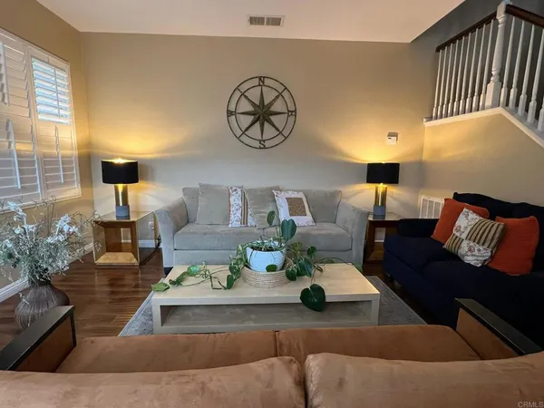 a living room with furniture and wooden floor