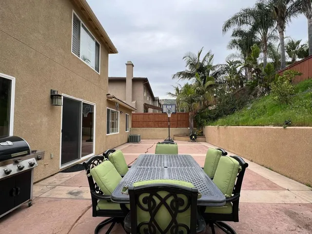 a view of a patio with table and chairs with wooden floor and fence