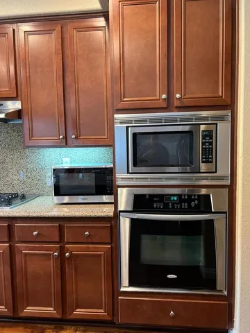 a kitchen with granite countertop cabinets stainless steel appliances and wooden cabinets