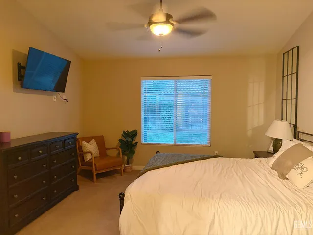 a bedroom with a bed and ceiling fan