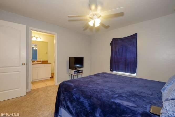 2927 4th Street Southwest Lehigh Acres, FL 33976 - Photo 17 of 19 a bedroom with a bed and a chandelier