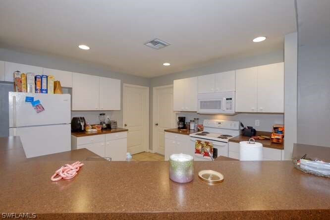 2927 4th Street Southwest Lehigh Acres, FL 33976 - Photo 8 of 19 a kitchen with stainless steel appliances granite countertop a stove a sink a refrigerator and white cabinets