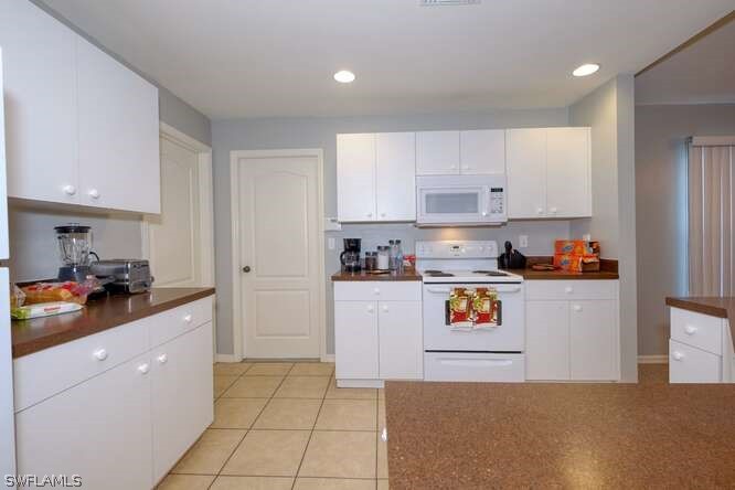 2927 4th Street Southwest Lehigh Acres, FL 33976 - Photo 9 of 19 a kitchen with white cabinets and appliances