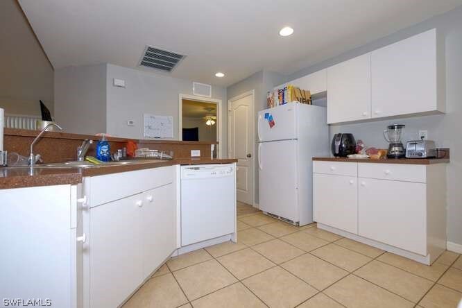 2927 4th Street Southwest Lehigh Acres, FL 33976 - Photo 10 of 19 a kitchen with a sink and refrigerator