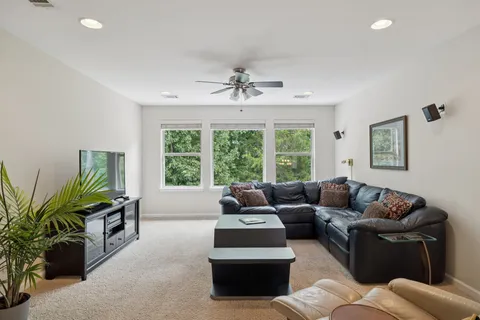 a living room with furniture a window and a flat screen tv