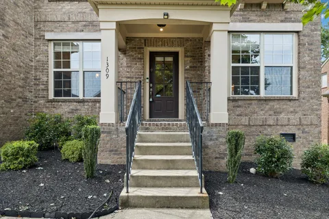 a front view of a house with potted plants