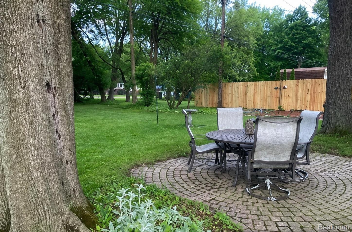 9552 Wayne Road Livonia, MI 48150 - Photo 27 of 31 Paver patio with a circular pattern, surrounded by a expansive lawn