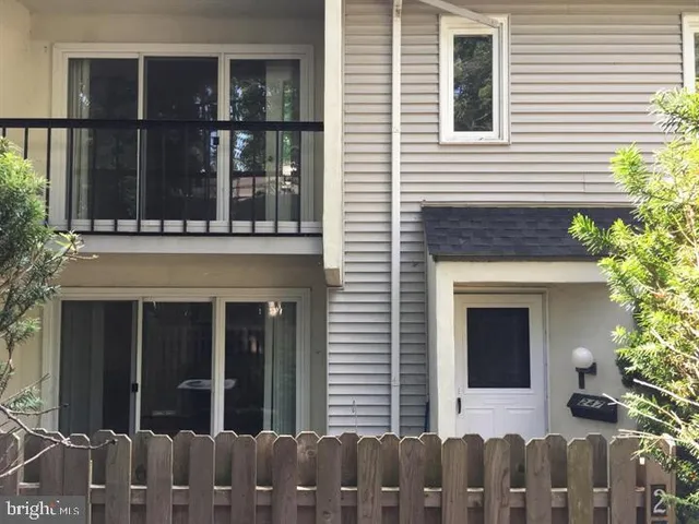 a view of a house with a window and wooden fence