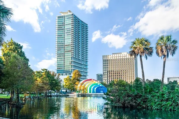 a front view of a house with a garden and lake view