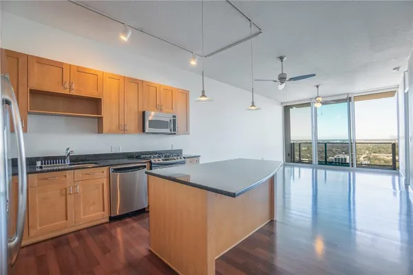 a kitchen with granite countertop a stove a sink and a refrigerator