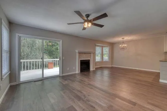 a view of empty room with wooden floor and fireplace