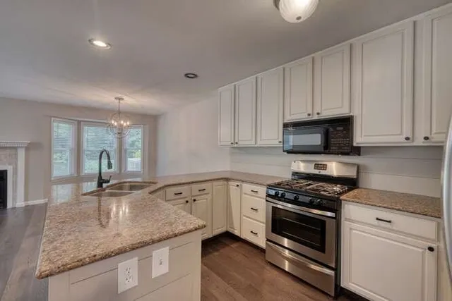 a kitchen with stainless steel appliances granite countertop a sink stove and cabinets