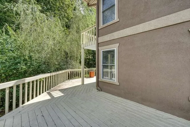 a balcony with wooden floor and fence