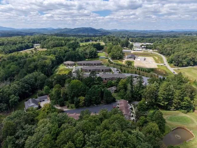 an aerial view of a house with a yard and lake view
