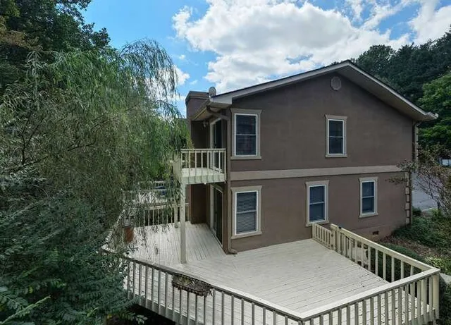 a view of a house with roof and wooden fence