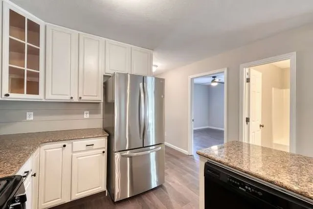 a kitchen with stainless steel appliances granite countertop a refrigerator and a stove top oven