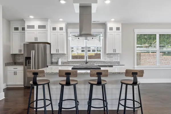 a kitchen with stainless steel appliances granite countertop counter space a center island cabinets and a window